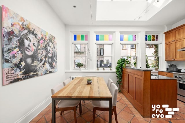 dining area featuring light tile patterned floors and baseboards