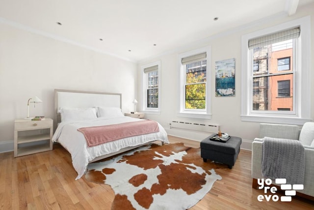 bedroom with ornamental molding, a baseboard radiator, light wood-style flooring, and baseboards