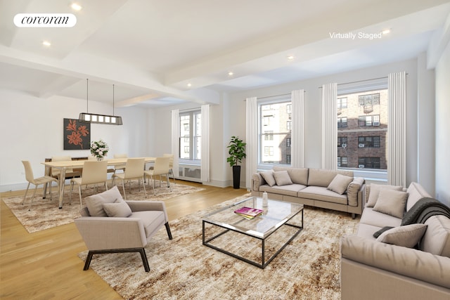 living area with wood finished floors, beamed ceiling, plenty of natural light, baseboards, and recessed lighting