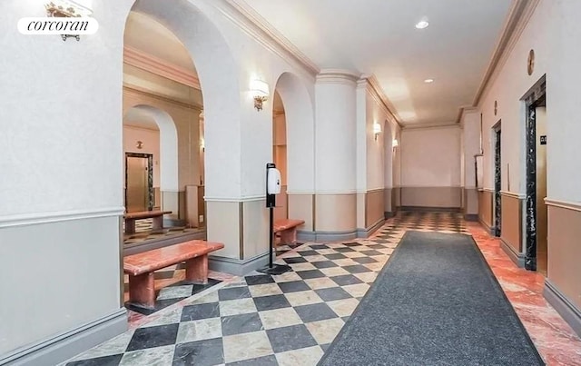 corridor with ornamental molding, arched walkways, wainscoting, and recessed lighting