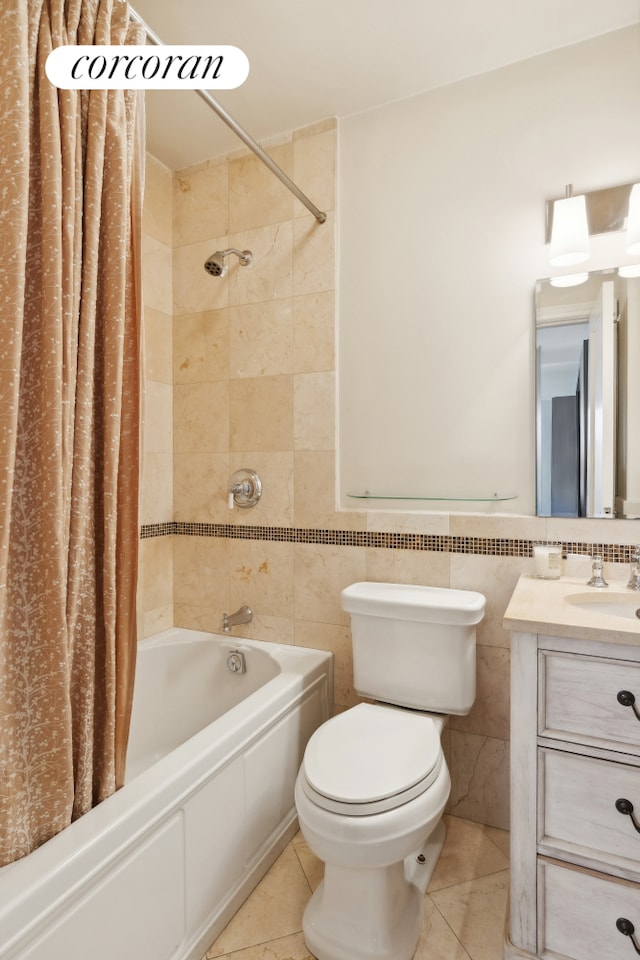 bathroom with tile walls, tile patterned flooring, shower / bath combo with shower curtain, vanity, and toilet