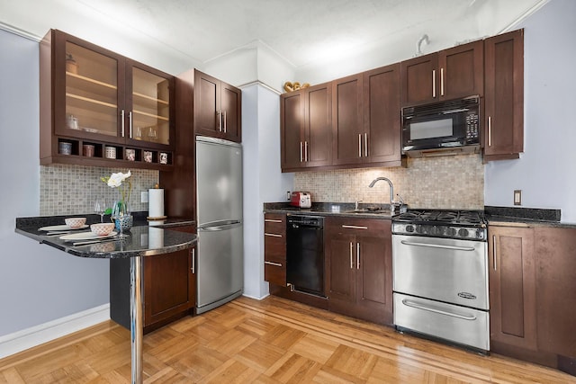 kitchen featuring dark brown cabinets, a sink, decorative backsplash, black appliances, and glass insert cabinets