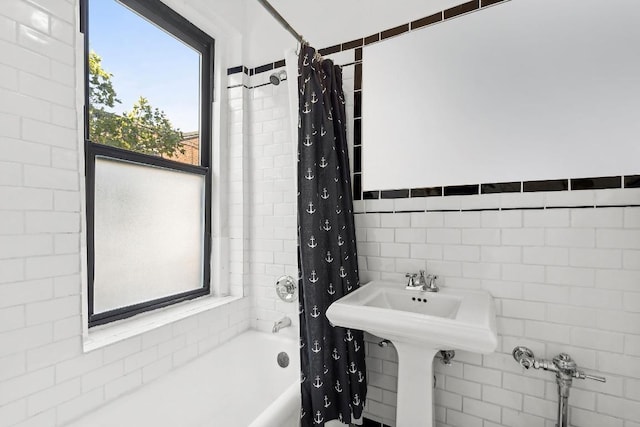 bathroom featuring tile walls and shower / bath combo with shower curtain