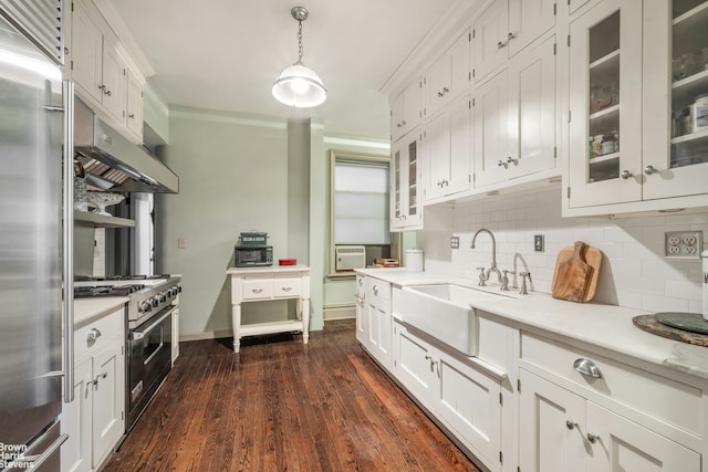 kitchen with light countertops, premium appliances, a sink, and white cabinetry