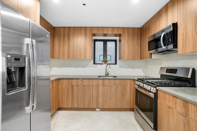 kitchen with a sink, stainless steel appliances, backsplash, and modern cabinets