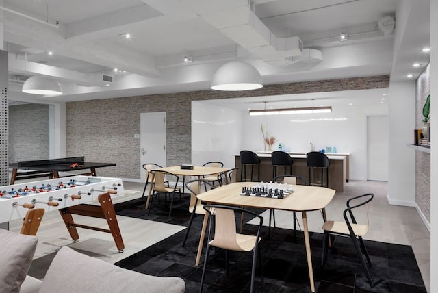 dining space featuring beam ceiling and bar