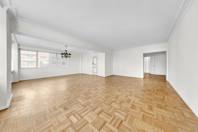 unfurnished living room with an inviting chandelier, baseboards, and crown molding