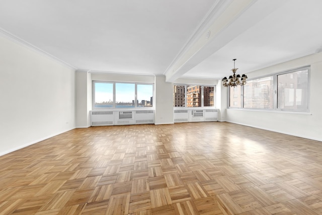 unfurnished living room featuring radiator heating unit, baseboards, crown molding, and a chandelier