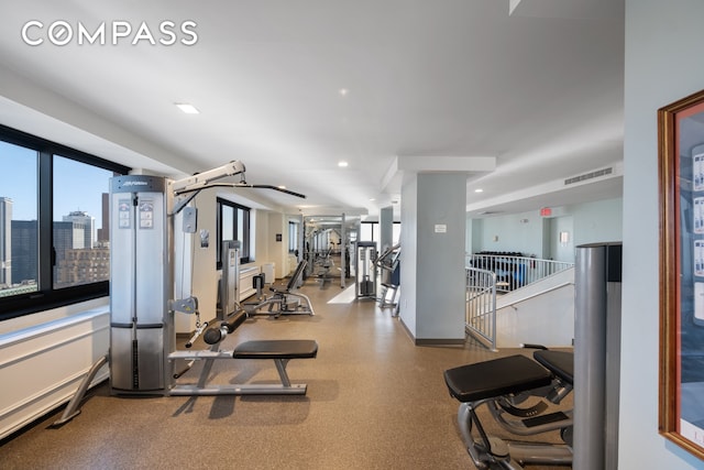 gym featuring a view of city, recessed lighting, and visible vents