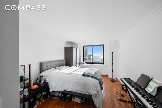 bedroom featuring wood finished floors, baseboards, and ornamental molding