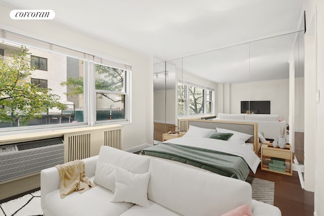 bedroom with hardwood / wood-style flooring and multiple windows