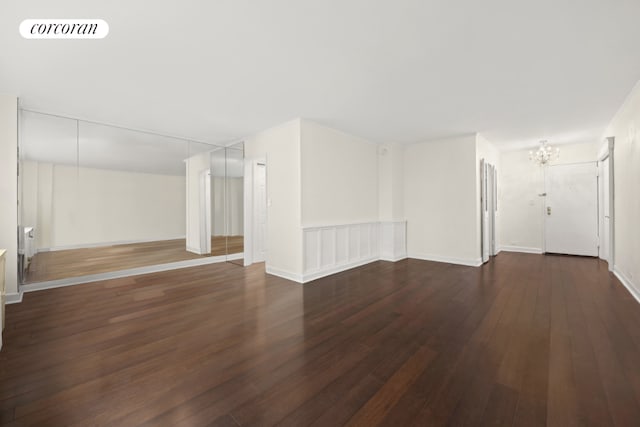 empty room featuring dark hardwood / wood-style flooring and a chandelier