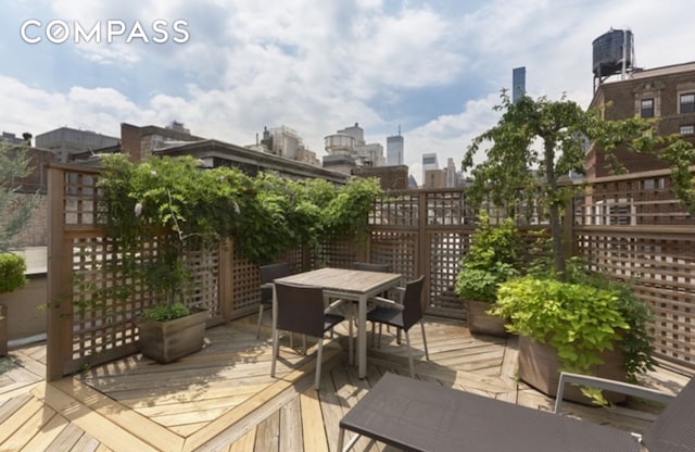 wooden deck featuring outdoor dining area and a city view