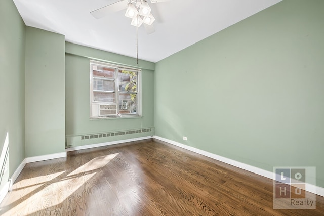 unfurnished room with a baseboard radiator, ceiling fan, baseboards, and wood finished floors