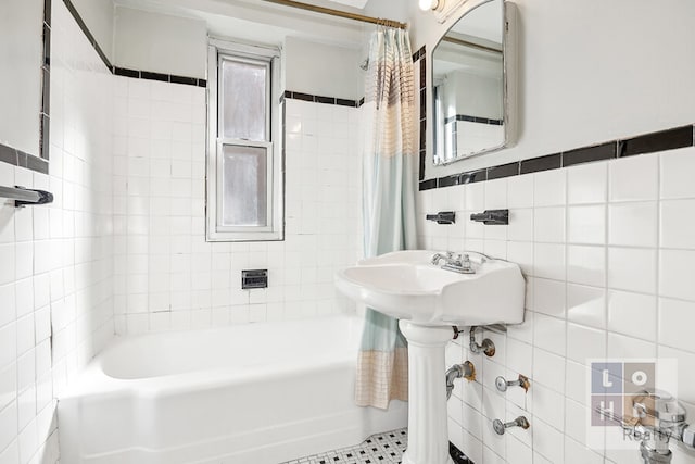 full bathroom with tile walls and shower / tub combo with curtain