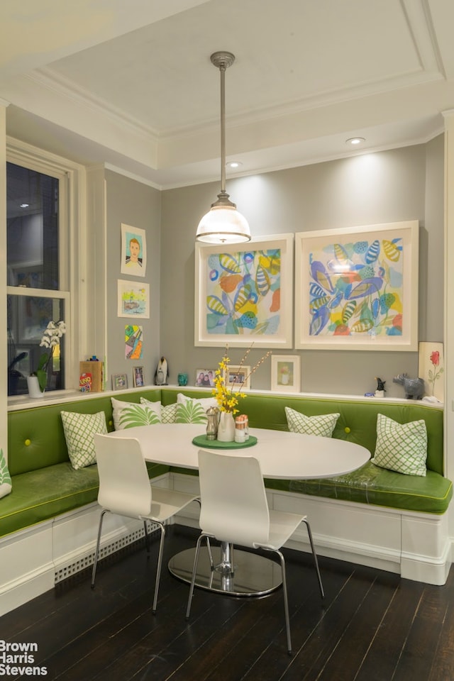 dining area featuring breakfast area, crown molding, a tray ceiling, and wood-type flooring