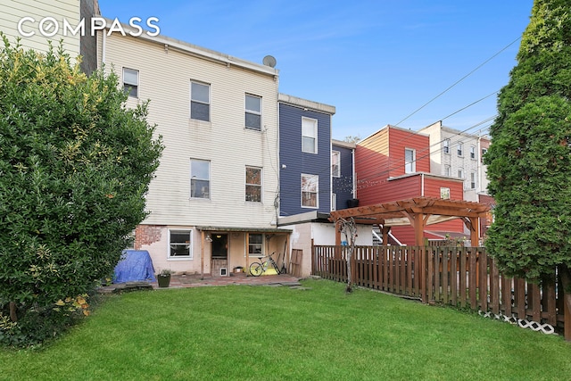 rear view of property with a patio area, fence, a lawn, and a pergola