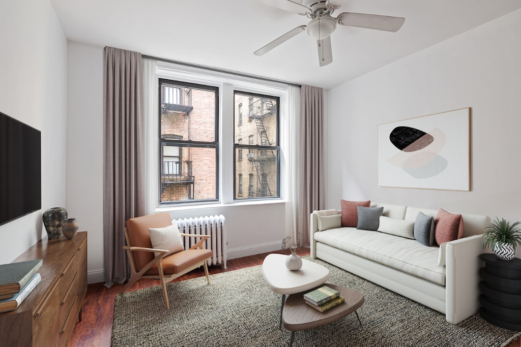 living room featuring dark hardwood / wood-style flooring, radiator, and ceiling fan