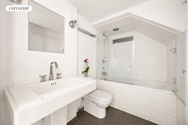 bathroom with tiled shower / bath combo, toilet, and tile patterned floors