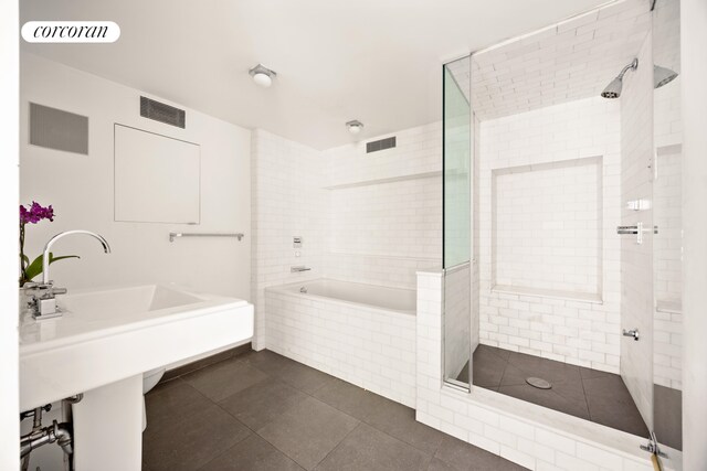 bathroom with tile patterned flooring, tiled shower, and visible vents