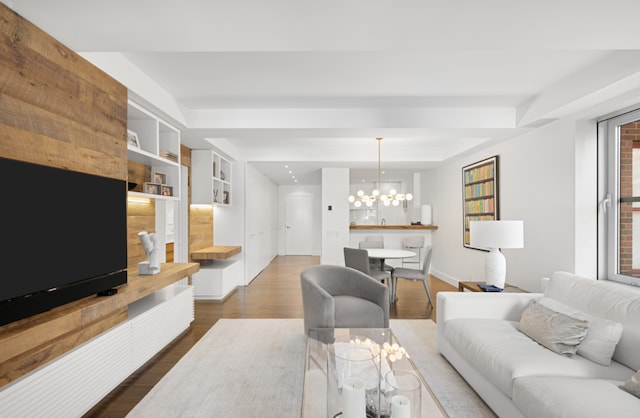 living room with dark hardwood / wood-style flooring, a raised ceiling, and a notable chandelier