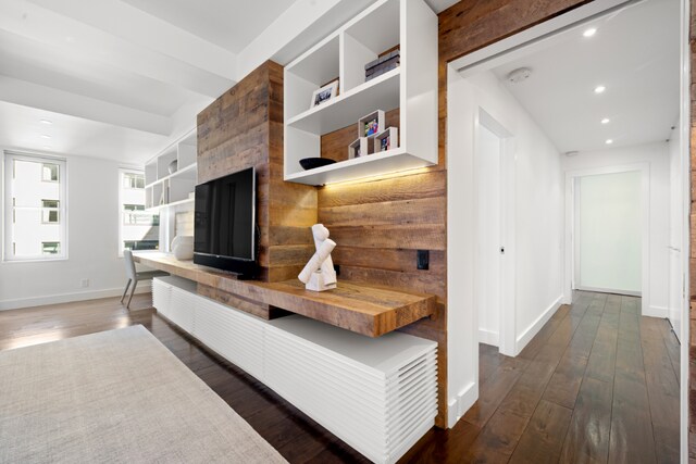 living room featuring built in features, dark wood-type flooring, and a chandelier