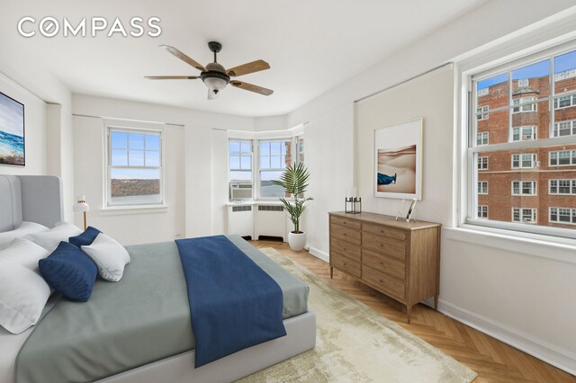 bedroom with ceiling fan, light parquet flooring, and multiple windows