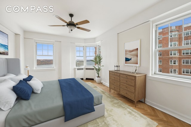 bedroom with a ceiling fan, radiator heating unit, and baseboards