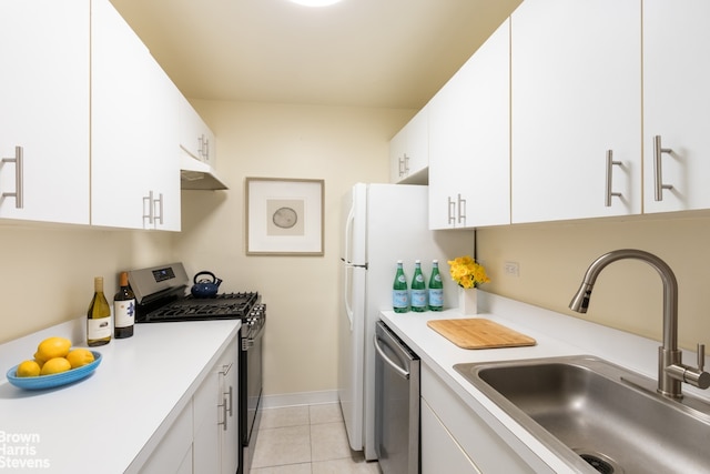 kitchen with sink, light tile patterned flooring, white cabinets, and appliances with stainless steel finishes