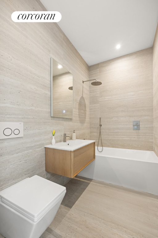 bathroom featuring vanity, shower / washtub combination, and tile walls