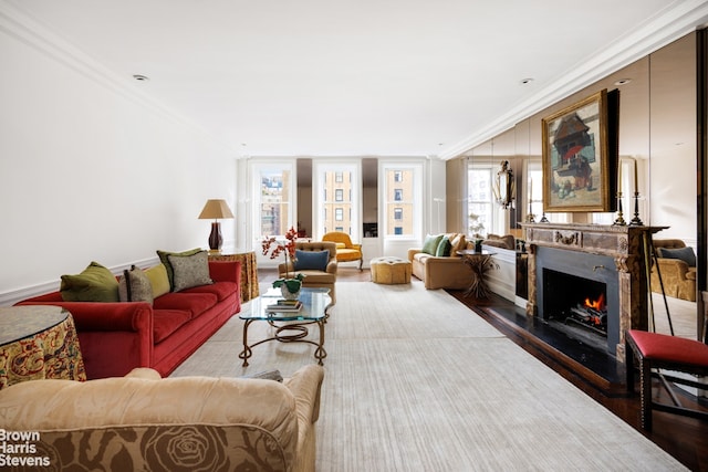 living area with a fireplace, wood finished floors, and crown molding