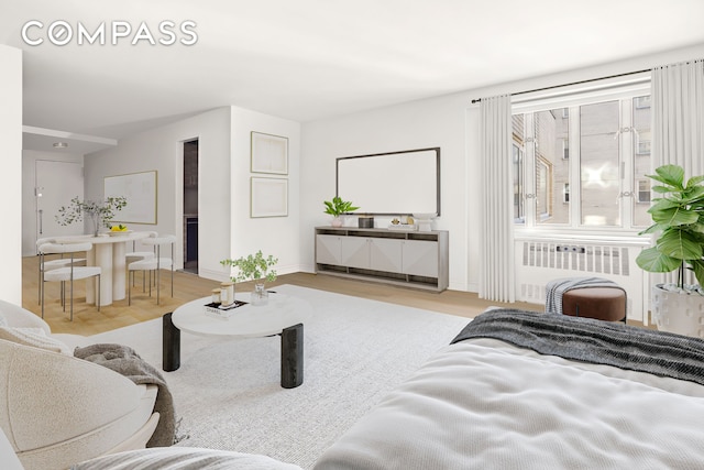 living area featuring baseboards, radiator heating unit, and wood finished floors