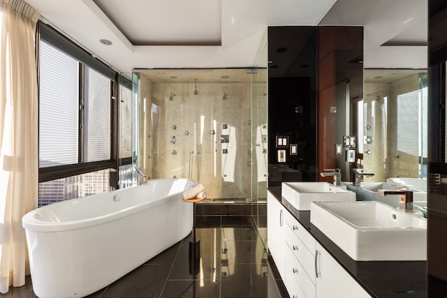 bathroom with vanity, shower with separate bathtub, a raised ceiling, and tile patterned floors