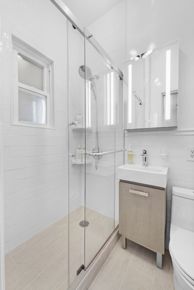 bathroom featuring tile walls, tile patterned flooring, vanity, walk in shower, and toilet