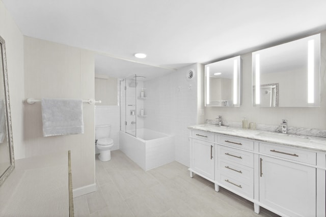 full bathroom featuring tiled shower / bath, vanity, and toilet