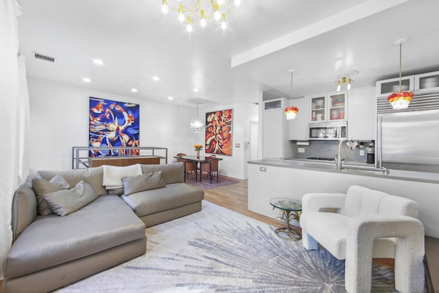 living room featuring a notable chandelier and light hardwood / wood-style floors