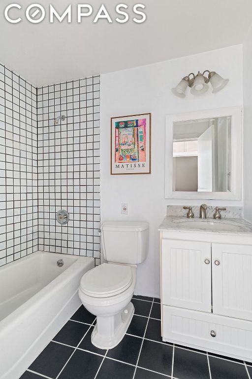 full bathroom featuring vanity, tiled shower / bath combo, tile patterned floors, and toilet