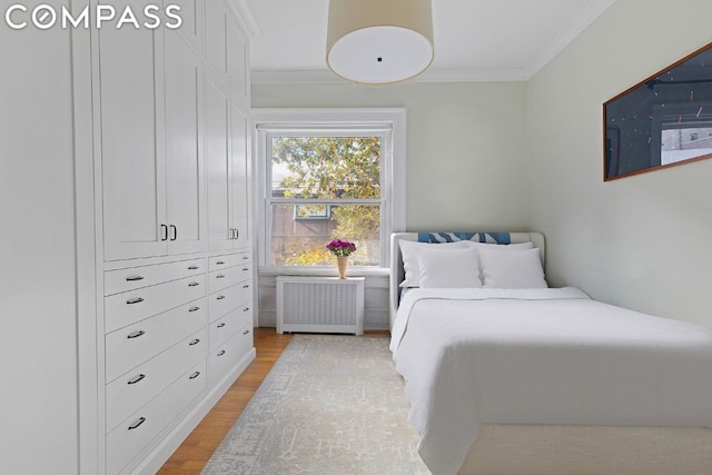 bedroom with radiator, crown molding, and light hardwood / wood-style floors