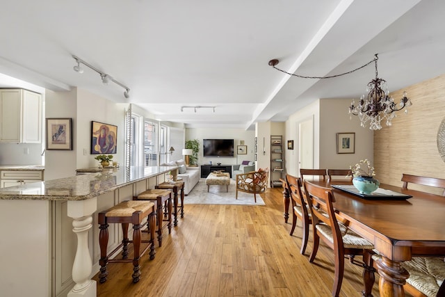 dining room with light wood-style floors, a chandelier, and rail lighting