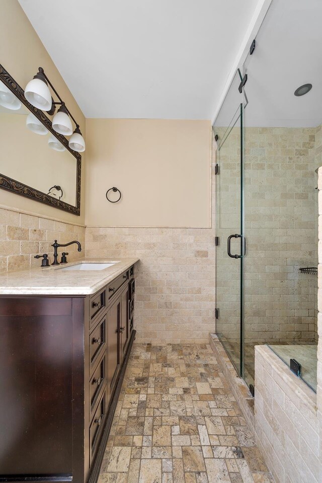 339 E 58th St Unit 7Cd, New York City, NY 10022 - bathroom with tile walls, a shower stall, vanity, and a wainscoted wall