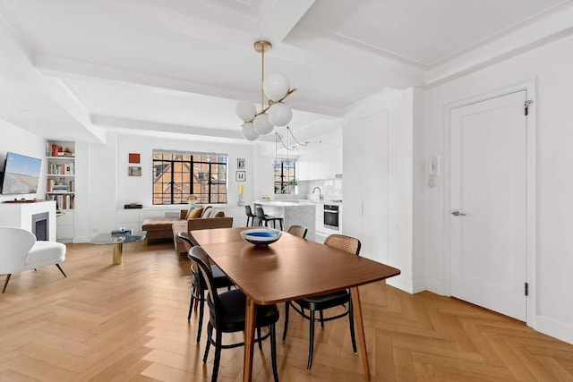 dining space with an inviting chandelier, beam ceiling, built in features, and light parquet flooring