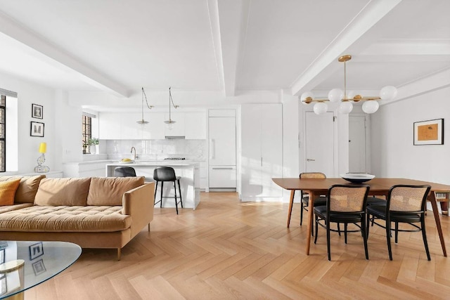 dining space featuring beamed ceiling and light parquet floors