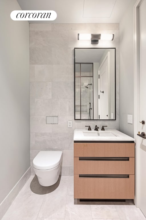 bathroom featuring tile walls, toilet, vanity, and tile patterned flooring