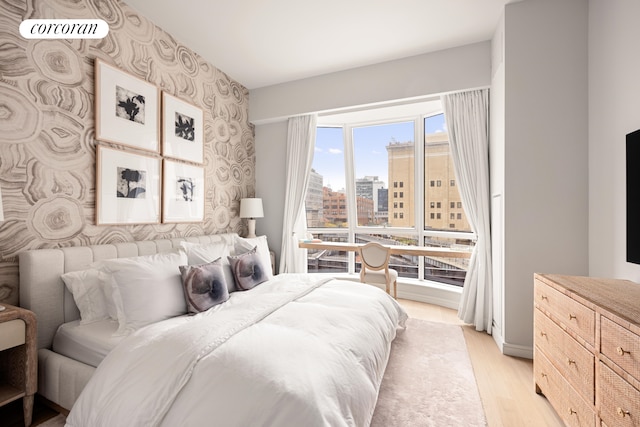 bedroom featuring light wood-style floors and wallpapered walls