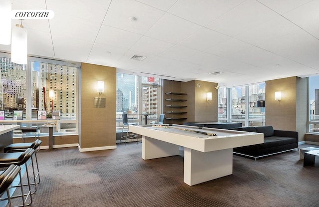 game room with a wall of windows, billiards, and dark colored carpet