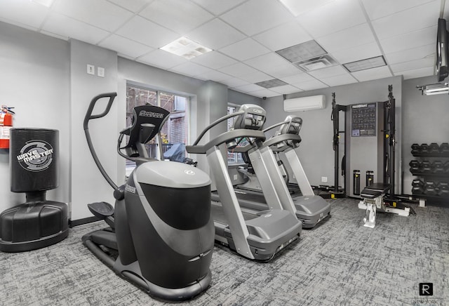 gym with an AC wall unit, carpet flooring, a paneled ceiling, and visible vents