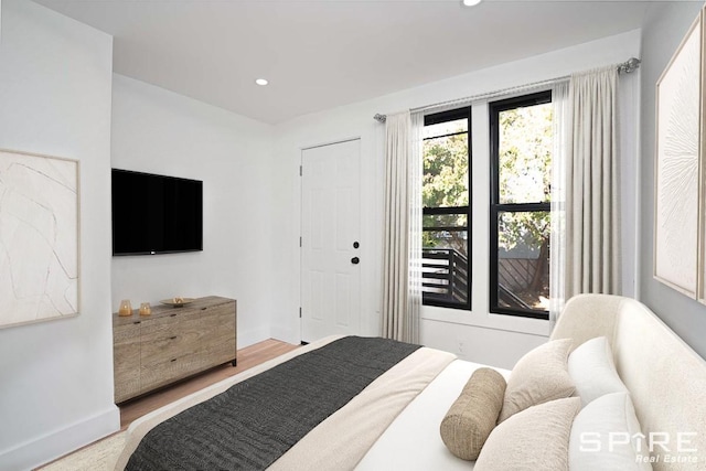 bedroom with wood finished floors, recessed lighting, and baseboards