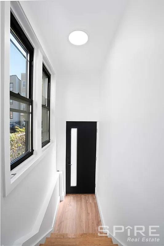 corridor featuring light wood-type flooring and baseboards