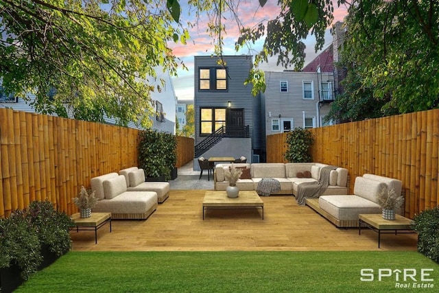 back of property featuring a fenced backyard, a wooden deck, and an outdoor hangout area