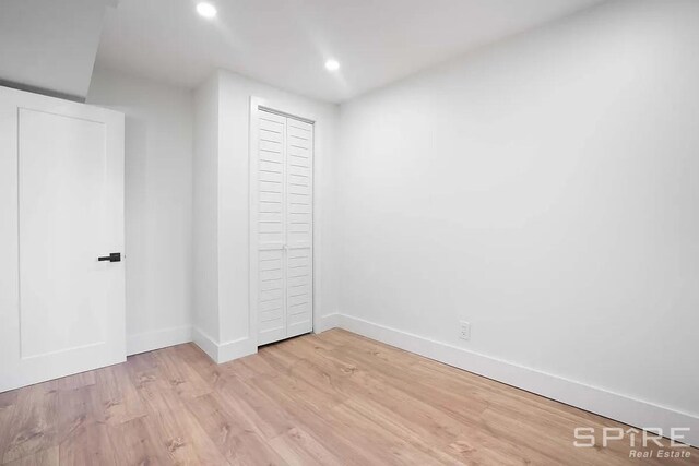 unfurnished bedroom featuring a closet, recessed lighting, light wood-style flooring, and baseboards